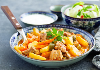 Beef stew with tomato sauce in a pan on wooden background. azu.