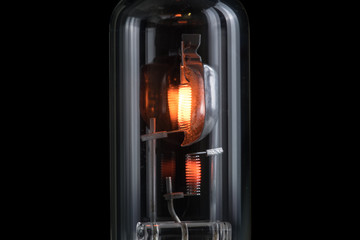 Incandescent lamp for dipped and main beam headlights with burning spiral on a black background