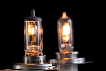 Incandescent lamp for dipped and main beam headlights with burning spiral on a black background