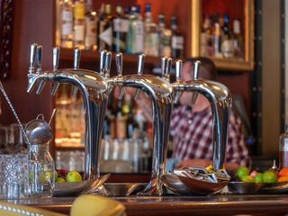 Silver steel beer taps with liquor and bartender