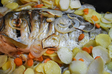 Carp baked in pots with potatoes and onions. Baked fish