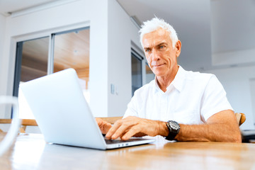 Fototapeta na wymiar Man working on laptop at home