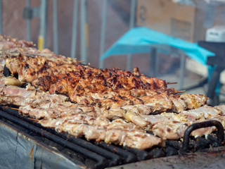 Skewers of pork and chicken sitting on a grill