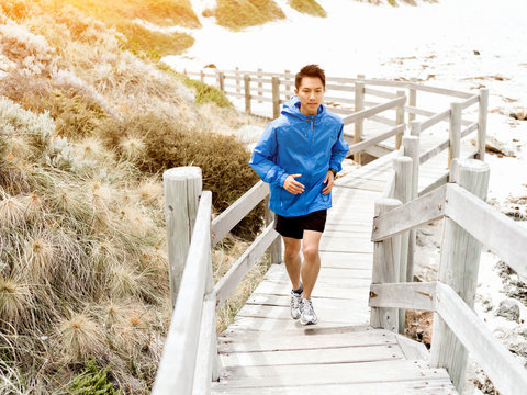 Young man running along seaside