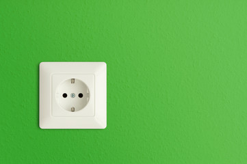 electrical power socket on green wall, green electric power outlet, European standard