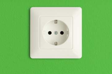 electric power socket on green wall,  electrical outlet, green power and renewable energy