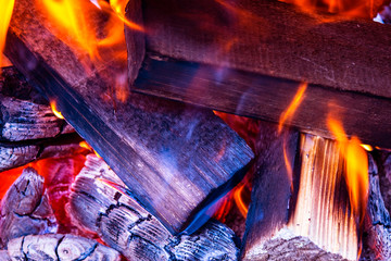 Burning firewood in the fireplace close up, BBQ fire, charcoal background. Charcoal fire with sparks. Fire background