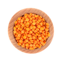 Red lentils in the wooden bowl isolated on white backgroun