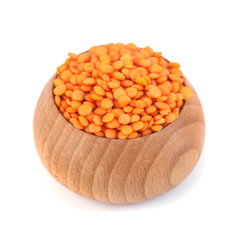 Red lentils in the wooden bowl isolated on white backgroun