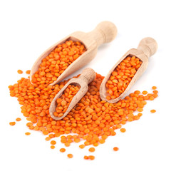 Red lentils in the wooden spoon, isolated on white background