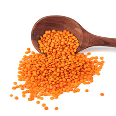 Red lentils in the wooden spoon, isolated on white background