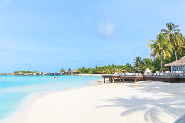Amazing island in the Maldives ,Beautiful turquoise waters and white sandy beach with  blue sky  background for holiday vacation .