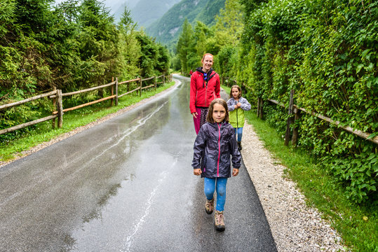 Family hiking on road in nature on a rainy day.