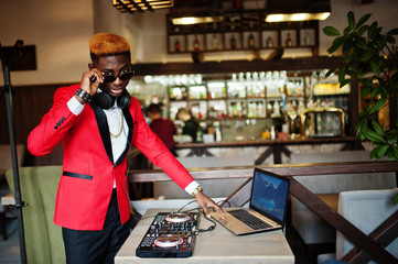 Fashion african american man model DJ at red suit with dj controller.