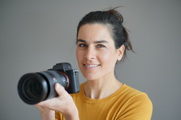 Fototapeta premium Portrait of stunning brunette photographer on grey isolated background