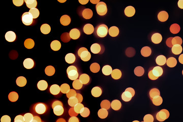 Yellow Christmas Tree Bokeh on black background of defocused glittering lights, Christmas background pattern concept