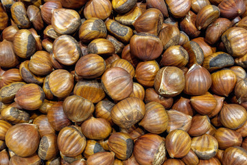 pile of chestnuts in shell closeup, horizontal view from above