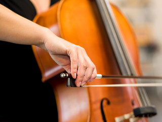 Close up of cello with bow in hands