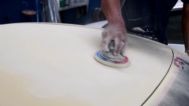 Working sanding primer before painting with random orbital sander (air tool)