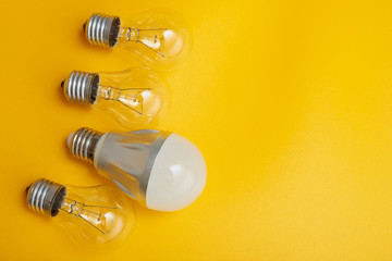 Led light bulb lay next to incandescent bulb. Concept energy saving