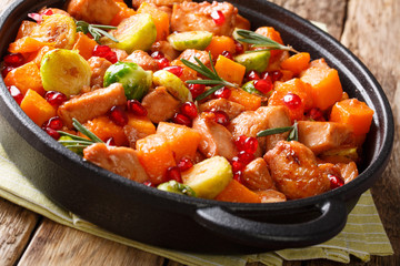 Organic food chicken pieces with vegetables and rosemary in pomegranate sauce close-up in a frying pan. horizontal