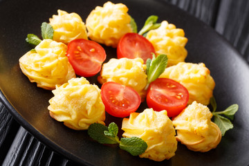 Hot baked Duchess Potatoes closeup on a plate on a wooden table. horizontal