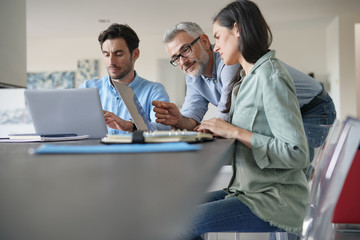  Young colleagues with older boss working with computers