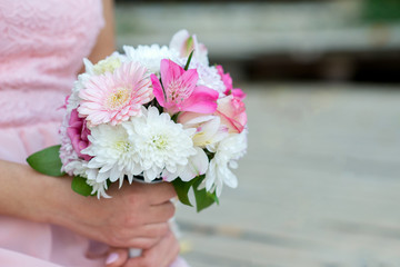 Glorious bridesmaids in pink dresses holding beautiful flowers - selective focus