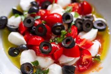 Mozzarella, tomato cherry, basil and olives salad