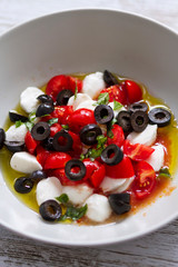 Mozzarella, tomato cherry, basil and olives salad