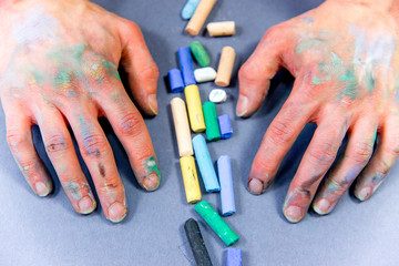 hands holding chalks and drawing on a blackboard