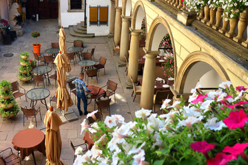 View on chairs and tables in cafe of Italian courtyard loggia arcade of the Korniakt palace (kamienica Krуlewska) on old town in the center of Lvov © watcherfox