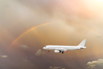 Fototapeta na wymiar Airplane and beautiful rainbow in the sky
