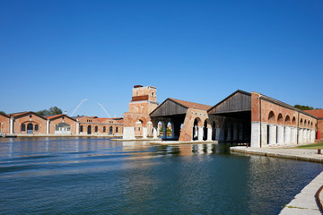 Venetian Arsenal with docks, canal and industrial building in a sunny day in Venice, Italy
