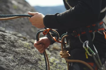 Gardinen Einfaches Sicherungs-Abseilgerät in den Händen einer Kletterer-Nahaufnahme. Kletterausrüstung und Ausrüstung. © esalienko