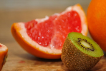 Various raw citrus fruit on wooden table. Close-up of lemon, orange, grapefruit and kiwi.