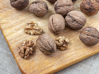 Peeled and unshelled walnuts on a wooden Board lie on the table covered with canvas cloth