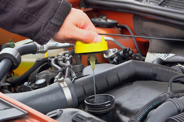 Automobile maintenance concept. Driver checking oil level in car engine. Close up.