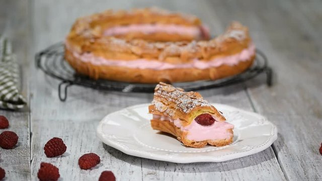 Homemade choux pastry cake Paris Brest with raspberries, almond, sugar powder. French dessert.