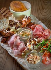 antipasto, antipasti - plate with pate, prosciutto, bread, cheese, salami, ham, sausage, pork, hummus, mustard, tomato