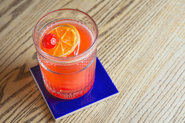 alcohol cocktail with cherry on it on the table in the bar
