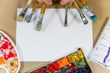 several paintbrushes with paint on a table