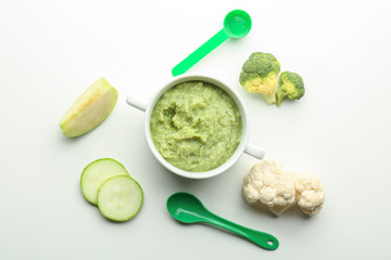 Flat lay composition with healthy baby food in casserole and ingredients on white background