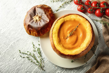 Tasty cream soup served in pumpkin on plate