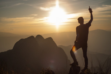 silhouette of man on top of mountain at sunset