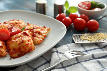 Plate with cooked ravioli on table