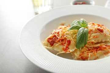 Plate with cooked ravioli on table, closeup