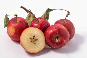 Small apple with green leaf on white background. ranetka