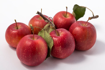 Small apple with green leaf on white background. ranetka