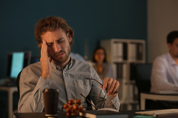 Tired IT specialist working in office